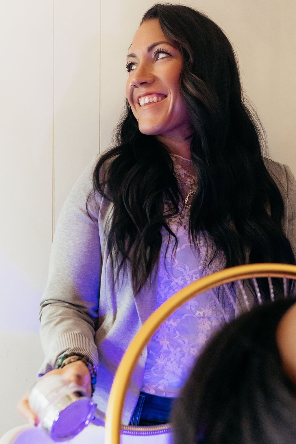 Smiling stylist with long dark hair using LED scalp therapy at A Shade of Vintage