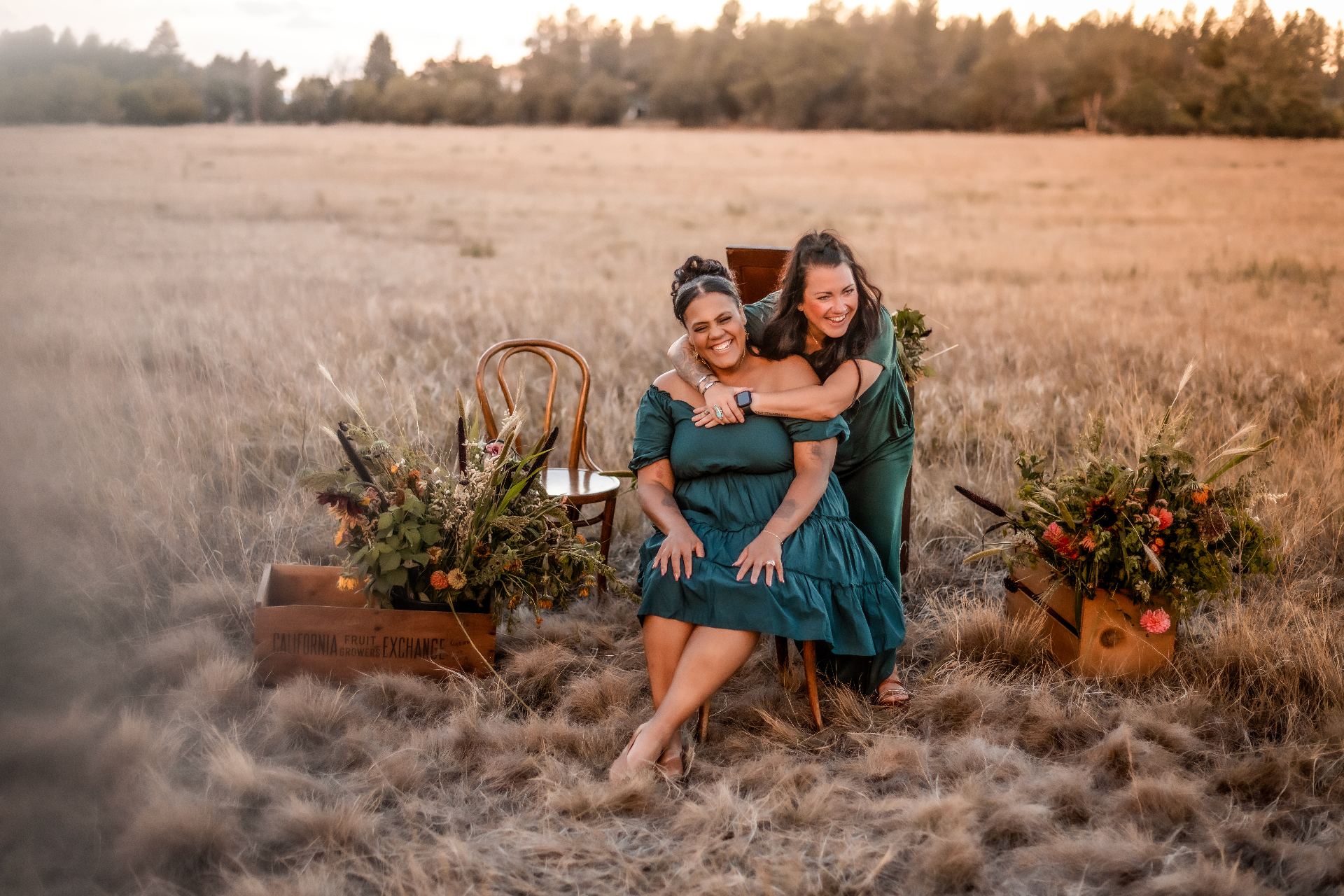 The A Shade of Vintage stylist team laughing together in a Wyoming field at golden hour